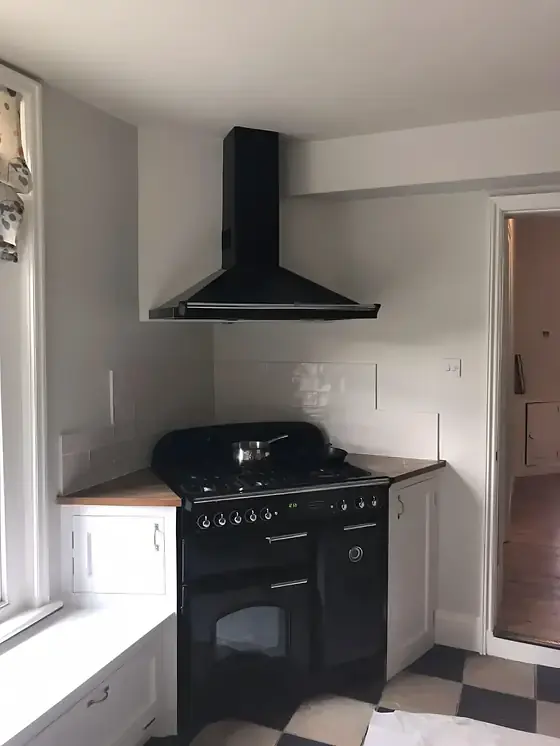 Cambridge kitchen redecorated in pale grey with black range cooker and chequered floor