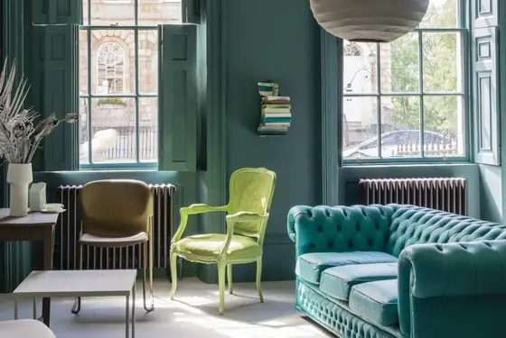 A Georgian sitting room painted in deep teal with green and turquoise furniture