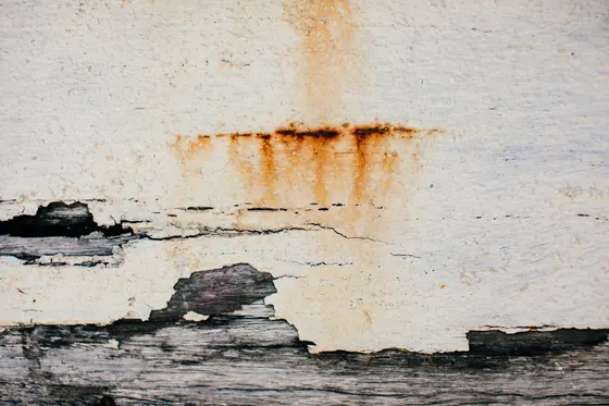 A wall with water staining and peeling paint