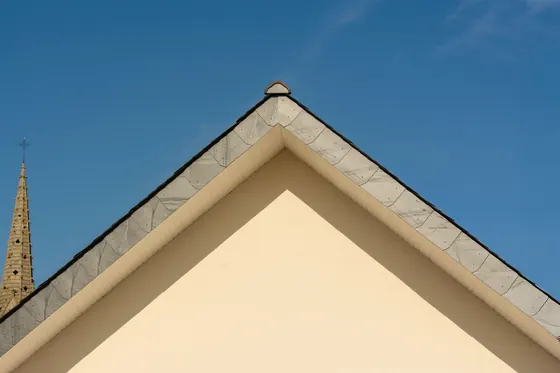 White bargeboards along the gable of a cream-rendered building